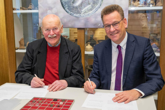 Rektor Prof. Dr. Johannes Wessels (r.) und Münzsammler Hermann Twiehaus unterzeichneten im Archäologischen Museum der WWU die Schenkungsurkunde. © WWU – Lianna Hecht.